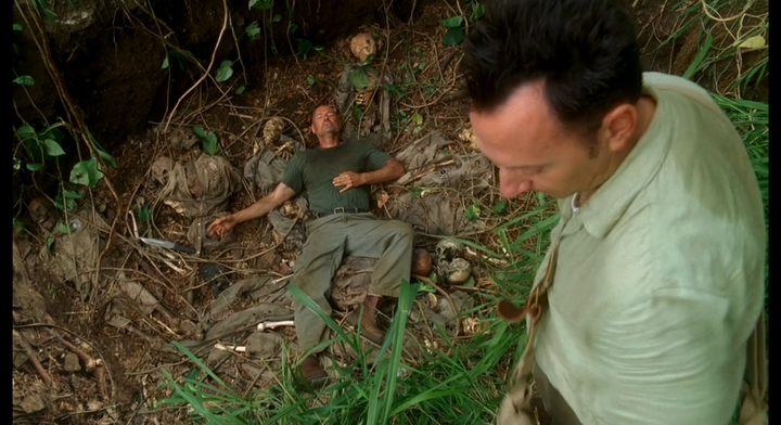 John Locke lies wounded in a mass grave. Ben Linus stands above.