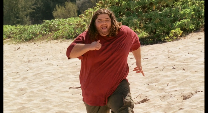 Hurley runs down a beach with a joyful expression.